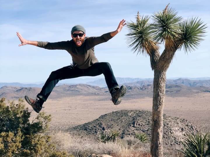 me jumping in the air next to a joshua tree